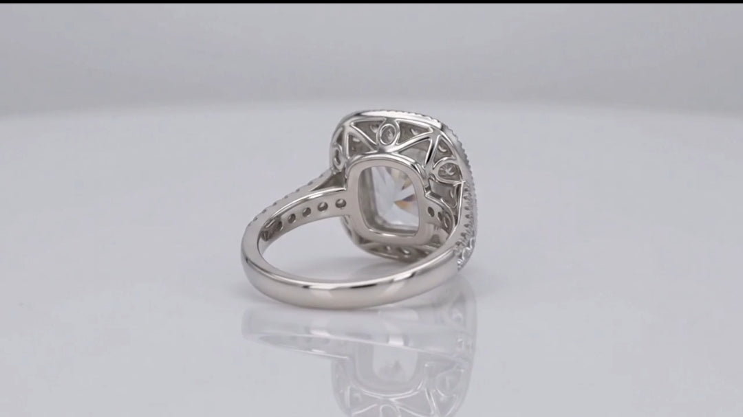 Bottom view showing intricate openwork filigree undergallery and polished inner band of a 3 carat cushion cut lab grown diamond halo ring.