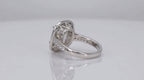 Rear side profile view revealing the detailed lattice gallery work and diamond-accented shoulders of a cushion cut engagement ring.