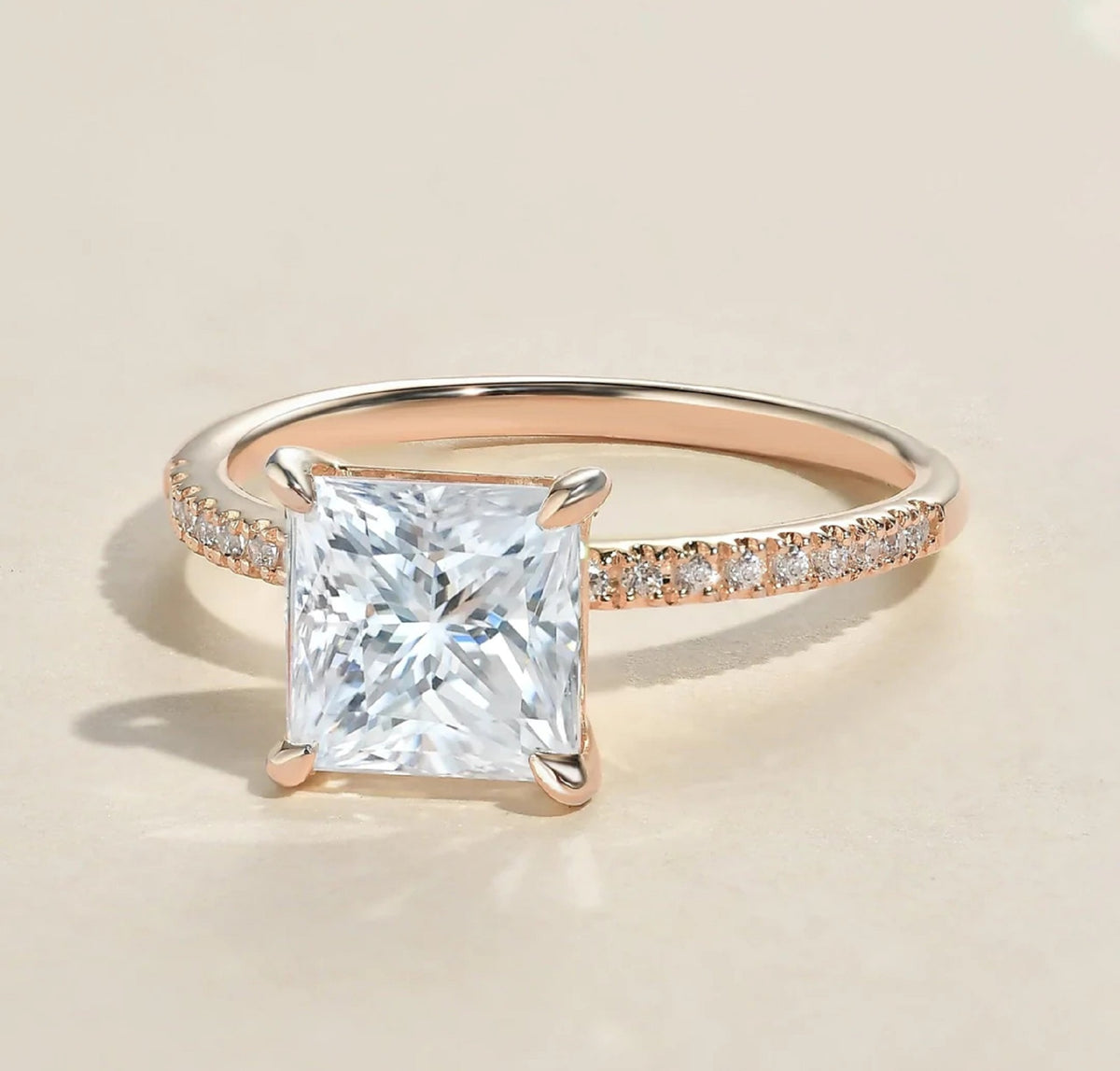 Three-quarter view of a 2 carat princess cut lab grown diamond ring with a thin rose gold pavé band.