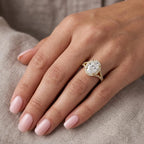 Model wearing a 3 carat oval lab grown diamond halo split-shank ring in yellow gold.