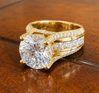 Perspective shot displaying the wide split shank, channel-set diamonds, and pavé borders of a yellow gold engagement ring.
