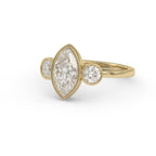 Top-down view of a 3 CT marquise lab-created diamond bezel ring with round side diamonds in polished 14K yellow gold.