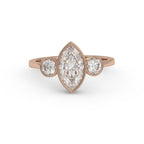 Direct top view of a 3 carat marquise cut lab diamond three-stone bezel engagement ring set in 14K rose gold.