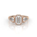Front view of a 3 carat emerald cut bezel set lab grown diamond ring with pear side stones in rose gold.