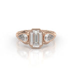 Front view of a 3 carat emerald cut bezel set lab grown diamond ring with pear side stones in rose gold.