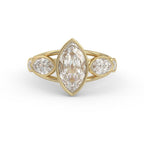 Front view of a 3 carat marquise cut lab grown diamond ring in a yellow gold bezel setting with side accent diamonds.