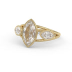 Three-quarter angled view of a 3 ct marquise bezel lab diamond engagement ring in yellow gold.