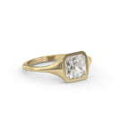 Three-quarter angled view of a 2 carat Asscher cut bezel set lab grown diamond ring in yellow gold.