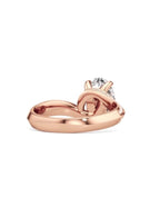 Back perspective showing the sculptural loop and smooth band of a rose gold bypass ring.