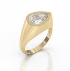 A yellow gold signet-style ring featuring a large pear-cut clear gemstone in a bezel setting, shown on a clean white background with a soft reflection below.