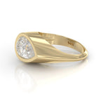 Top-down view of a 3 carat pear-cut lab created diamond flush set in a smooth yellow gold signet band.