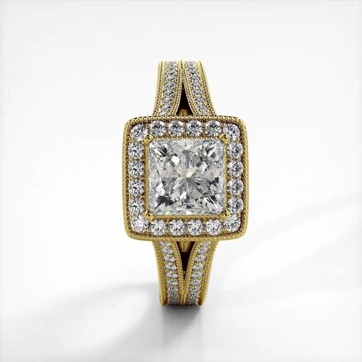 Top-down view of 2 CT princess cut lab grown diamond ring with milgrain halo and split shank in yellow gold.