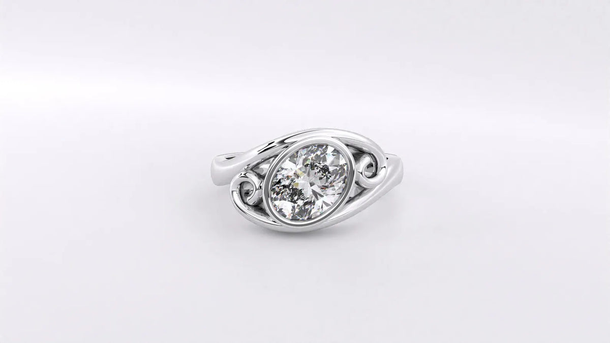 Top-down view of a 2 CT oval lab grown diamond ring with bypass bezel setting and scroll motif in white gold.