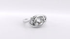 Close-up view of a 2 carat oval lab grown diamond framed in a bypass bezel setting with scroll accents.