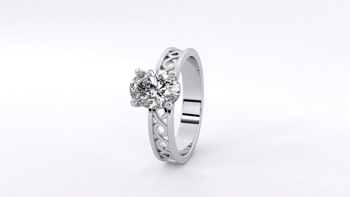 Angled top perspective view of white gold 2 carat oval diamond ring with intricate openwork filigree band.
