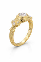 Angle view of yellow gold vintage bezel engagement ring with engraved shank details