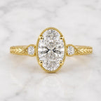 Top-down view of 2 Carat Oval Cut Lab Grown Diamond Engagement Ring showing milgrain trim, side accents, and chevron engraved band