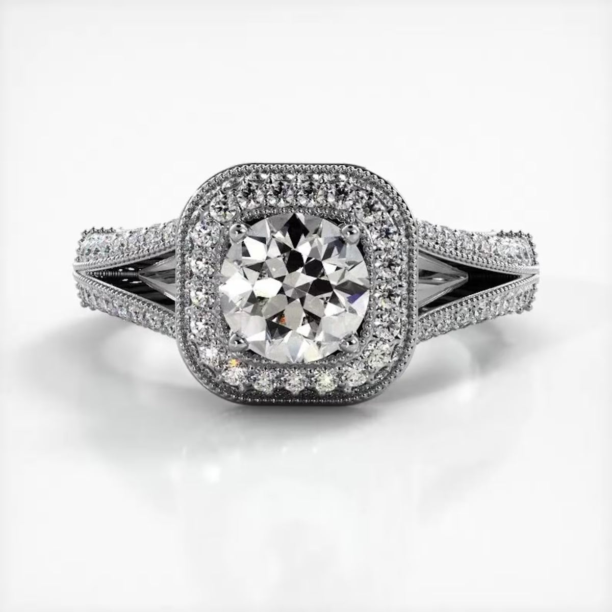 Top-down view of white gold engagement ring featuring a 2 CT round lab grown diamond framed by a milgrain cushion halo.