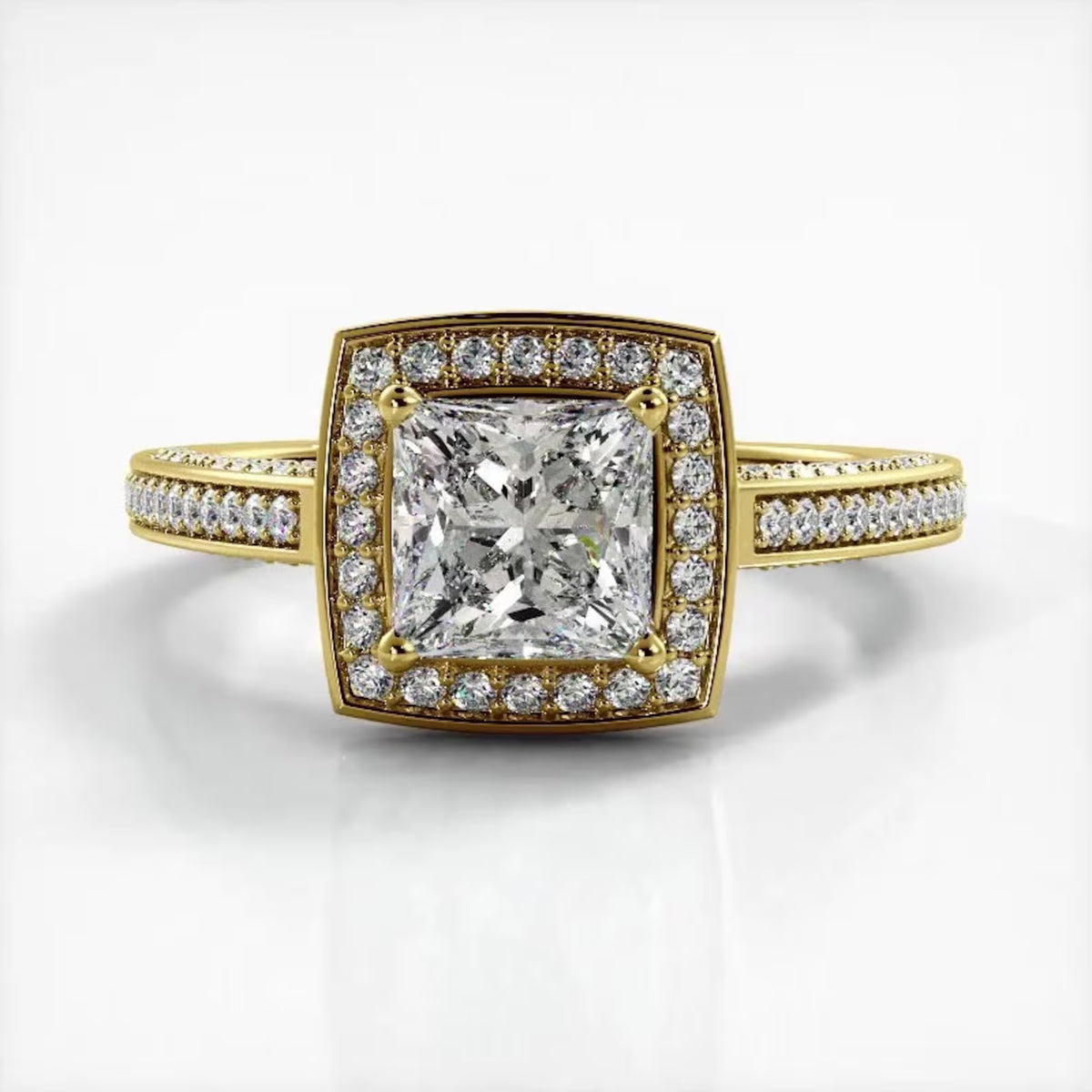 Top-down view of a 2 CT princess cut lab grown diamond engagement ring in yellow gold with cushion halo and milgrain pave band.