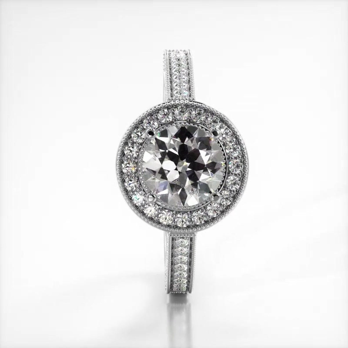 Vertical perspective top view of a white gold 3 CT round cut lab diamond ring with milgrain halo.