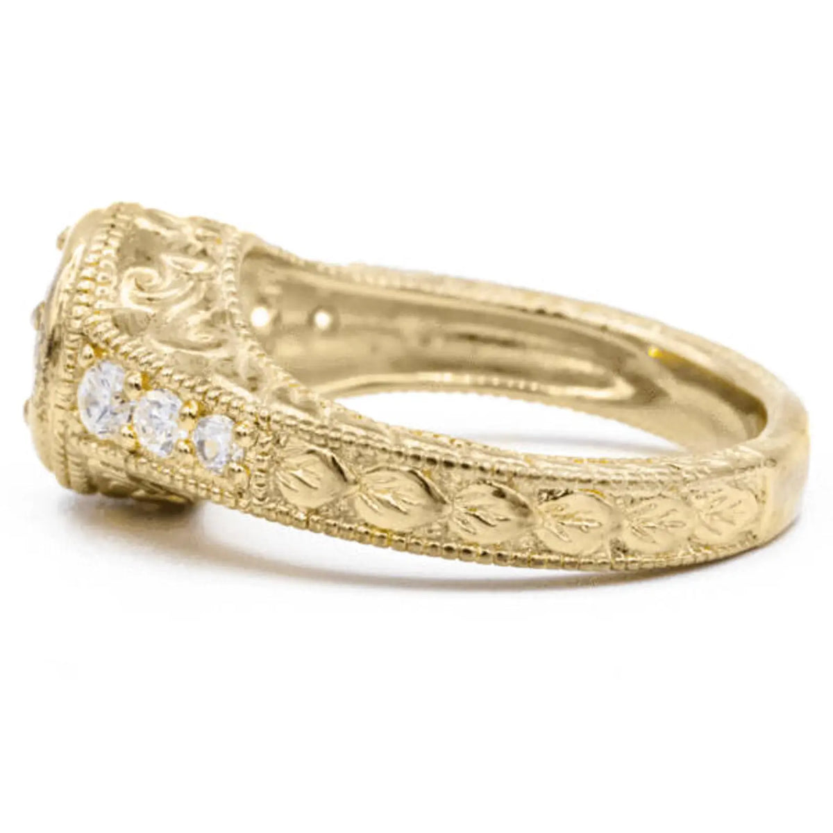 Side profile of yellow gold lab diamond vintage ring displaying detailed leaf scroll carving and milgrain edging