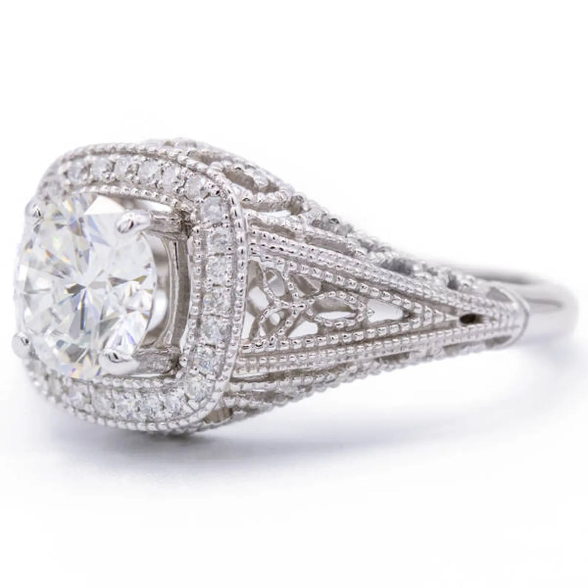 Three-quarter perspective of lab diamond cushion halo ring displaying side lace openwork detailing