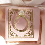 Profile view of yellow gold vintage Asscher diamond solitaire ring resting on a pink jewelry box