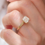 Top-down view of 2 carat Asscher lab diamond ring showing botanical leaf carved shank against pink background
