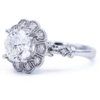 Three-quarter perspective angle of 3 carat round lab created diamond flower halo ring showing milgrain shoulder station