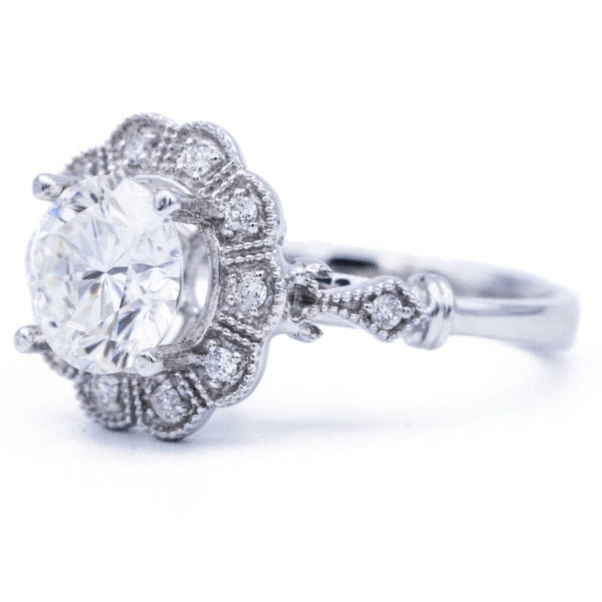 Three-quarter perspective angle of 3 carat round lab created diamond flower halo ring showing milgrain shoulder station
