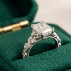 Side profile detail of a white gold 4 carat radiant cut lab diamond ring featuring antique scrollwork and milgrain detailing.