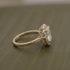 Side profile view of a 3 CT oval cut lab grown diamond engagement ring in yellow gold showing intricate filigree basket detail.