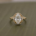 Top-down view of a 3 CT oval lab grown diamond ring with a scalloped halo accent frame and milgrain band.