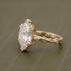 Side profile of a 4 carat Dutch marquise lab grown diamond ring featuring a hand-carved botanical vine band and prong setting in yellow gold.
