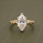 Top-down front view of a 4 CT Dutch marquise cut lab grown diamond solitaire engagement ring with V-prongs and a carved vine band.