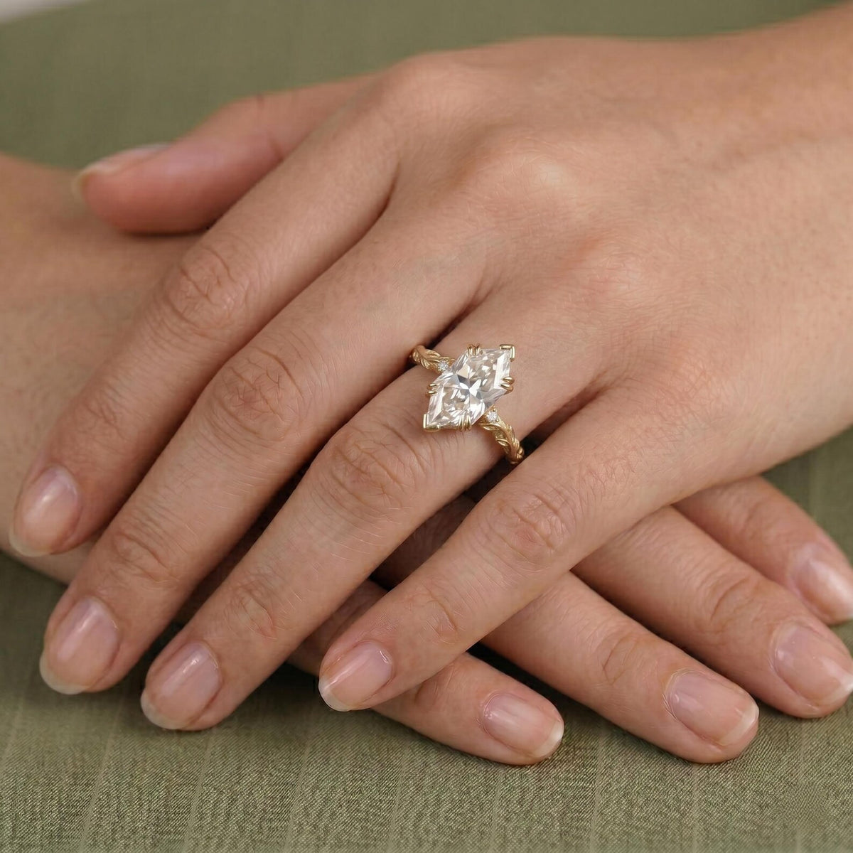 On-hand view of a 4 CT Dutch marquise cut lab grown diamond engagement ring with a nature-inspired yellow gold leaf band.