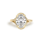 Top-down product studio view of a 3 carat oval lab grown diamond engagement ring in 14k yellow gold with milgrain rim detail.