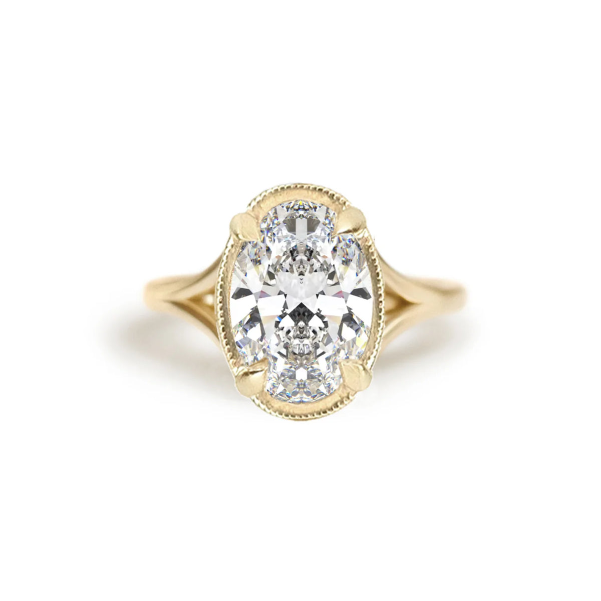 Top-down product studio view of a 3 carat oval lab grown diamond engagement ring in 14k yellow gold with milgrain rim detail.