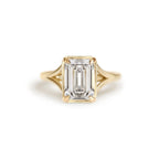 Front top-down studio view of a 3 carat emerald cut lab grown diamond ring in yellow gold featuring milgrain bezel frame.
