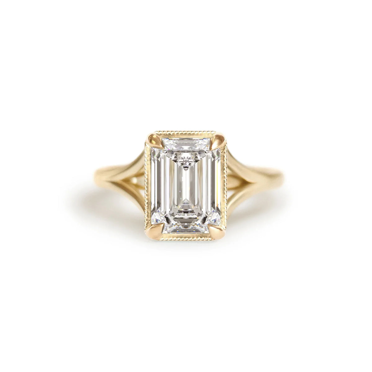 Front top-down studio view of a 3 carat emerald cut lab grown diamond ring in yellow gold featuring milgrain bezel frame.