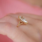 Studio top-down view of a 3 carat marquise cut lab created diamond ring set in 14k yellow gold with fine milgrain edging.