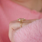 Perspective side view of a 3 carat marquise lab diamond engagement ring with split cathedral shoulders worn on a hand.