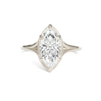 Profile view of a 3 carat marquise lab grown diamond solitaire ring on finger against a soft pink knit sweater.