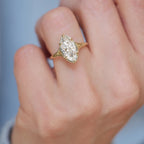 Close-up perspective photo of a 3 carat marquise lab diamond solitaire ring in yellow gold worn on a ring finger.