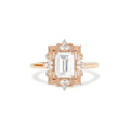 Studio top-down view of a 3 carat emerald cut lab grown diamond engagement ring crafted in 14k rose gold with an ornate Art Deco filigree halo frame.