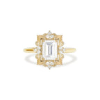 Studio macro front view of a 3 carat emerald cut lab grown diamond ring in 14k yellow gold with detailed vintage filigree halo.
