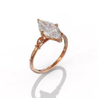 Perspective angle view of a 3 carat marquise lab grown diamond engagement ring set in 14K rose gold with milgrain accent shoulders.