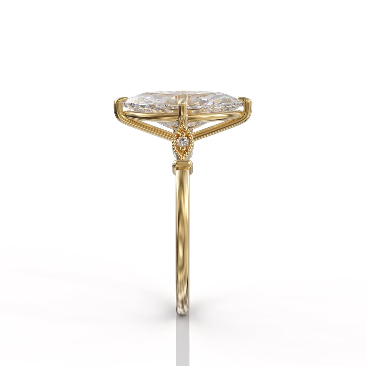 Direct side profile view of a yellow gold marquise lab diamond engagement ring displaying the bezel-set side accent stone.
