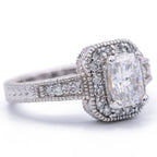 Perspective shot of a 3 CT radiant cut lab diamond engagement ring in white gold featuring a milgrain border and accent side stones.