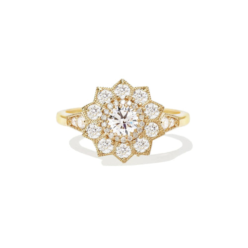 Studio portrait of a 1.5 carat round lab created diamond flower halo engagement ring set in 14K yellow gold.